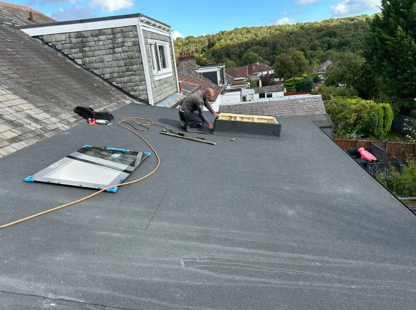 Roofer laying a new felt flat roof