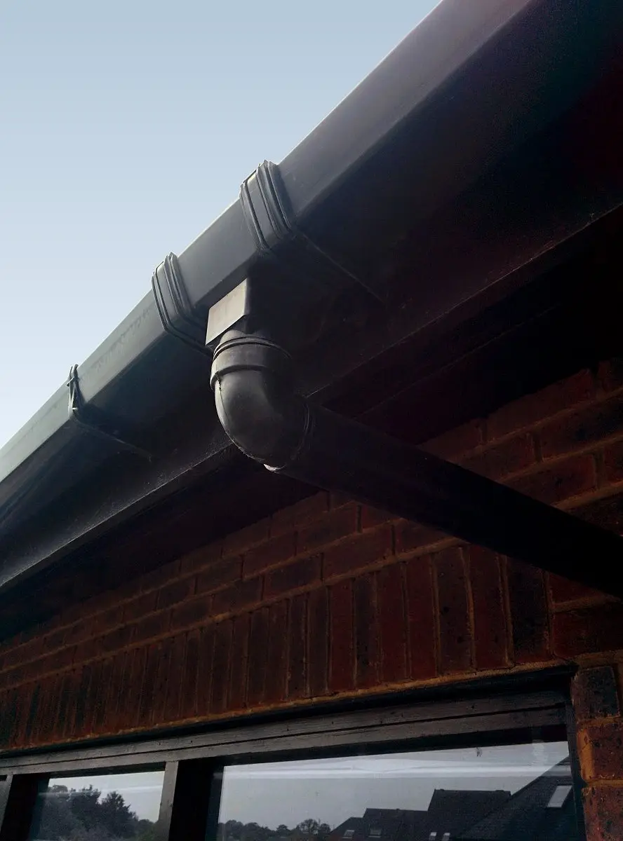 Black gutter and outlet on a brick house