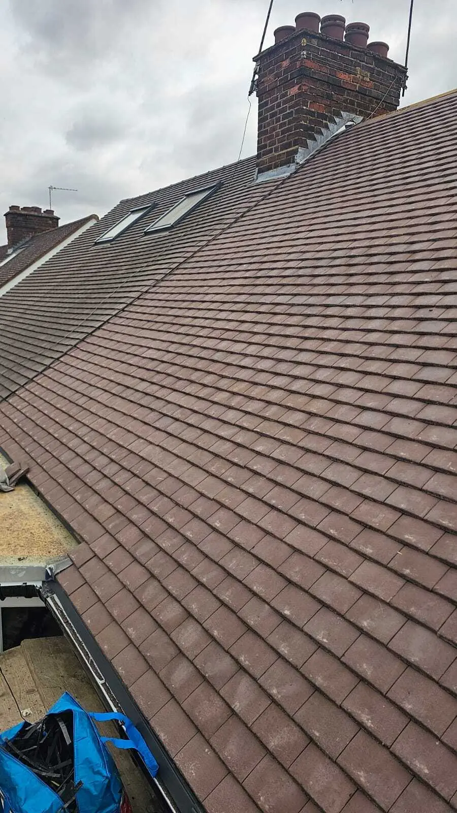 Newly tiled roof slope in brown plain tiles