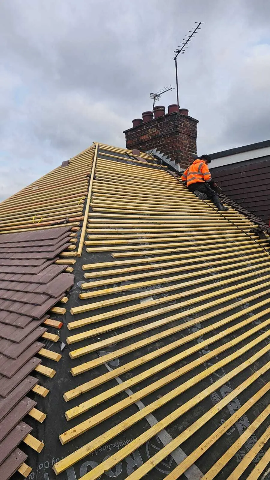 Roofer fixing battens on a re-roof