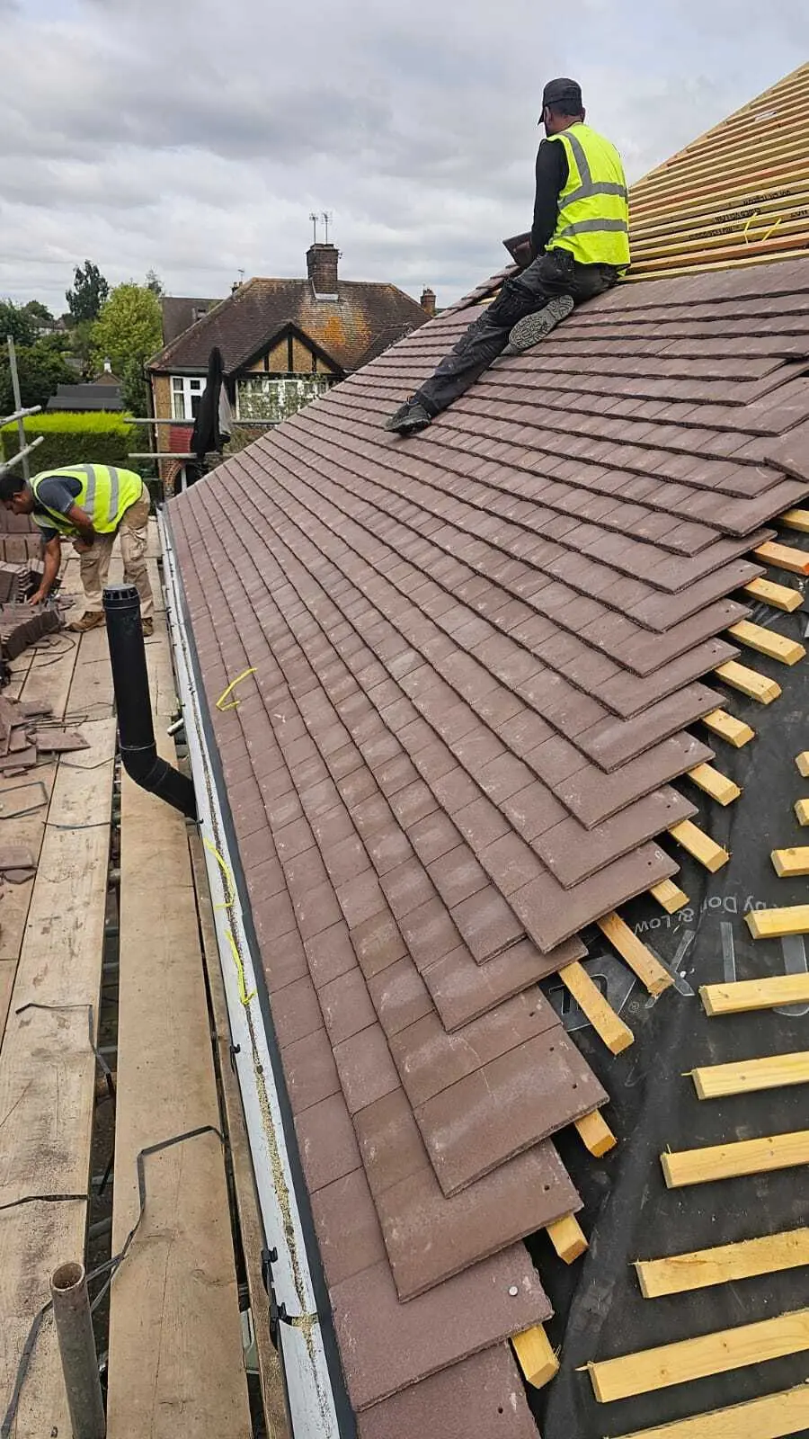 Roofer tiling up from the eaves on a re-roof