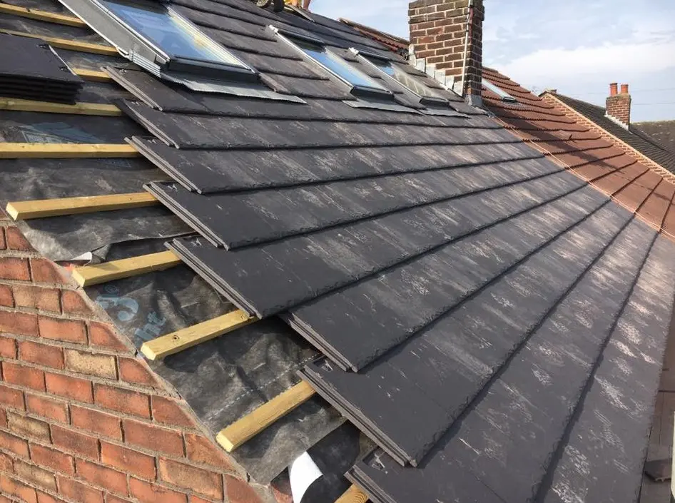 New slates being laid over battens on a house roof
