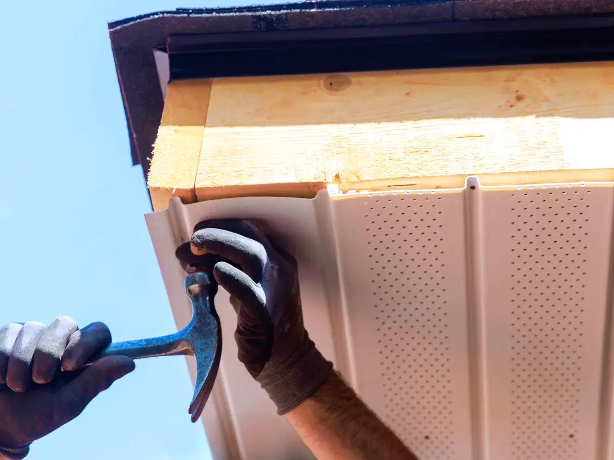 Tradesman fixing a new uPVC soffit board