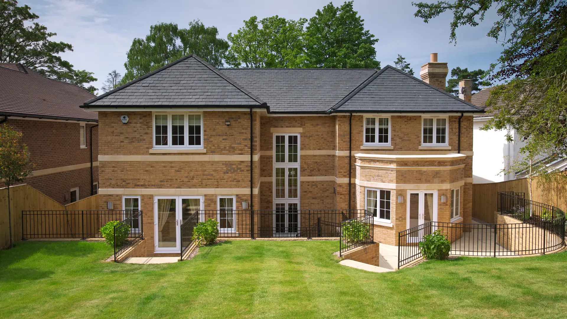 Detached brick house with a grey tiled roof and lawned garden