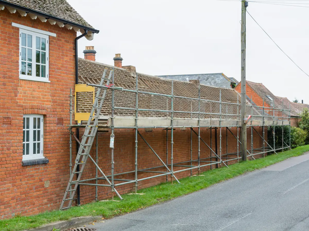 Scaffolding along the roof of a row of brick houses