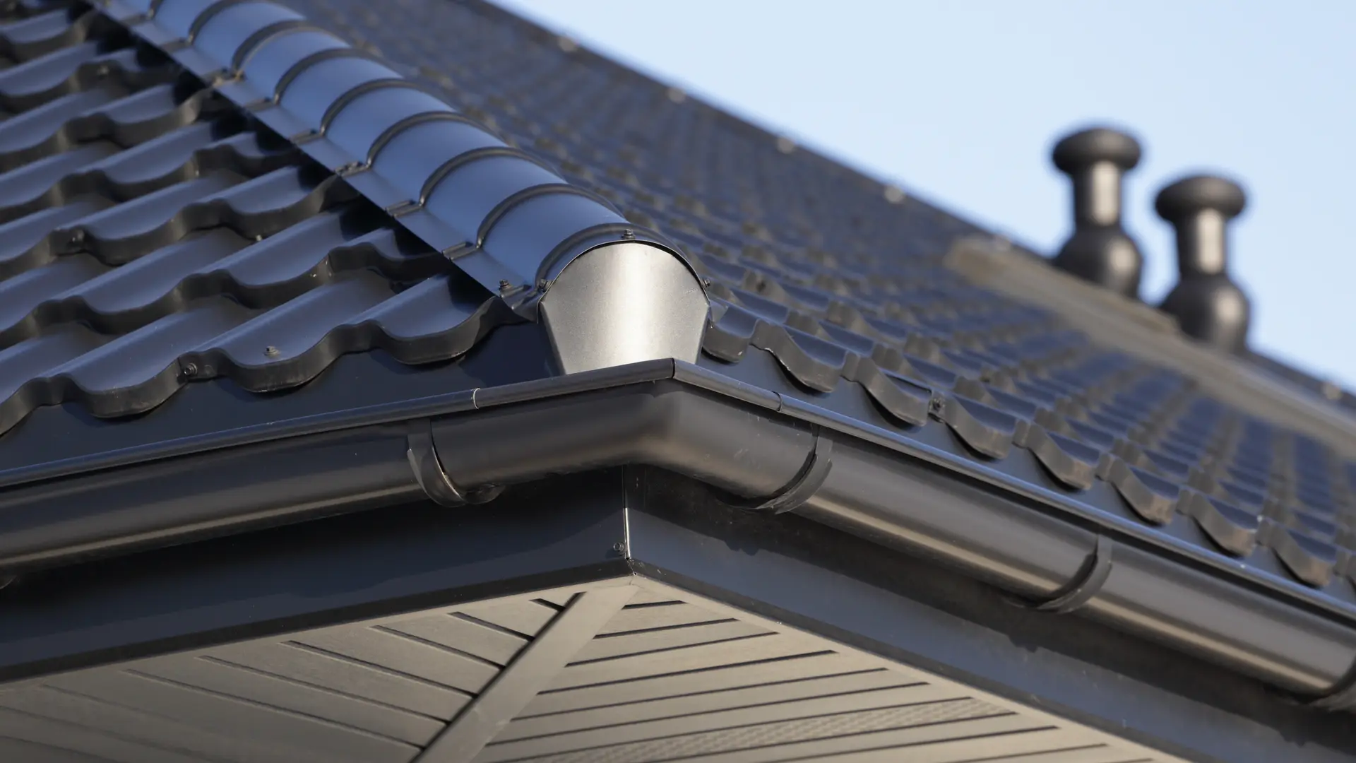 White soffit and dark gutter below a tiled roof