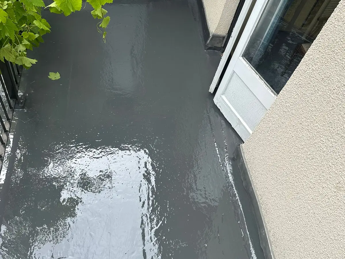 Freshly coated grey GRP balcony floor beside patio doors
