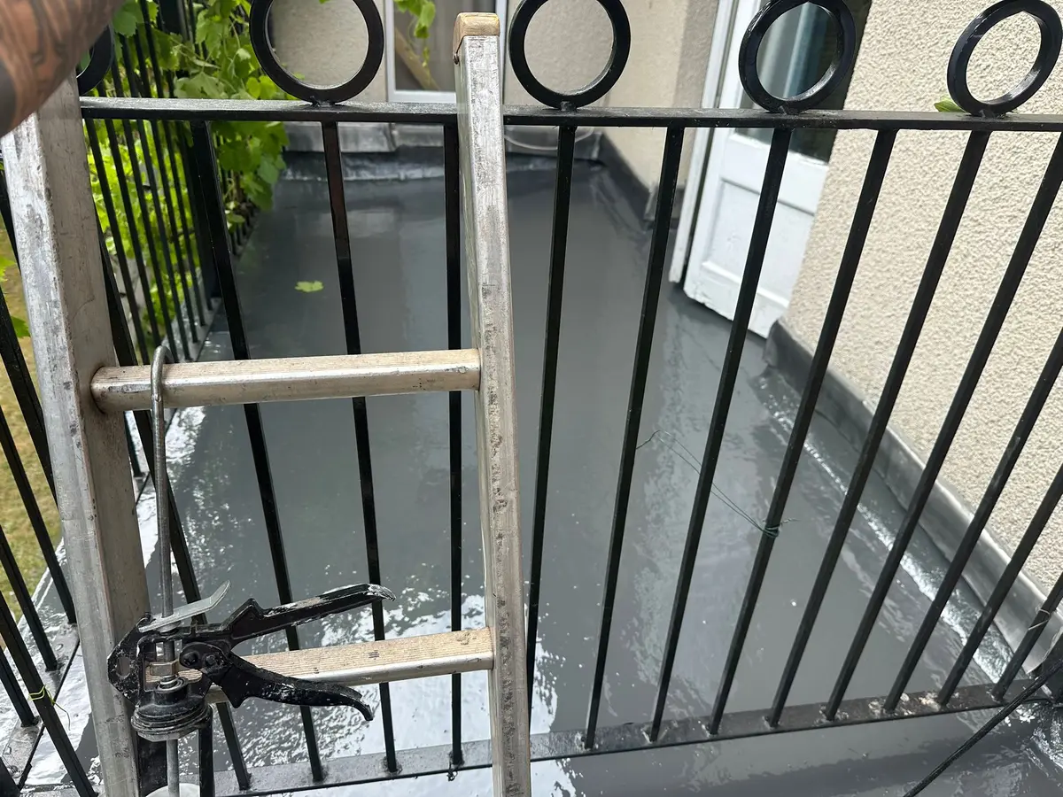 GRP fibreglass balcony with black railings and a ladder