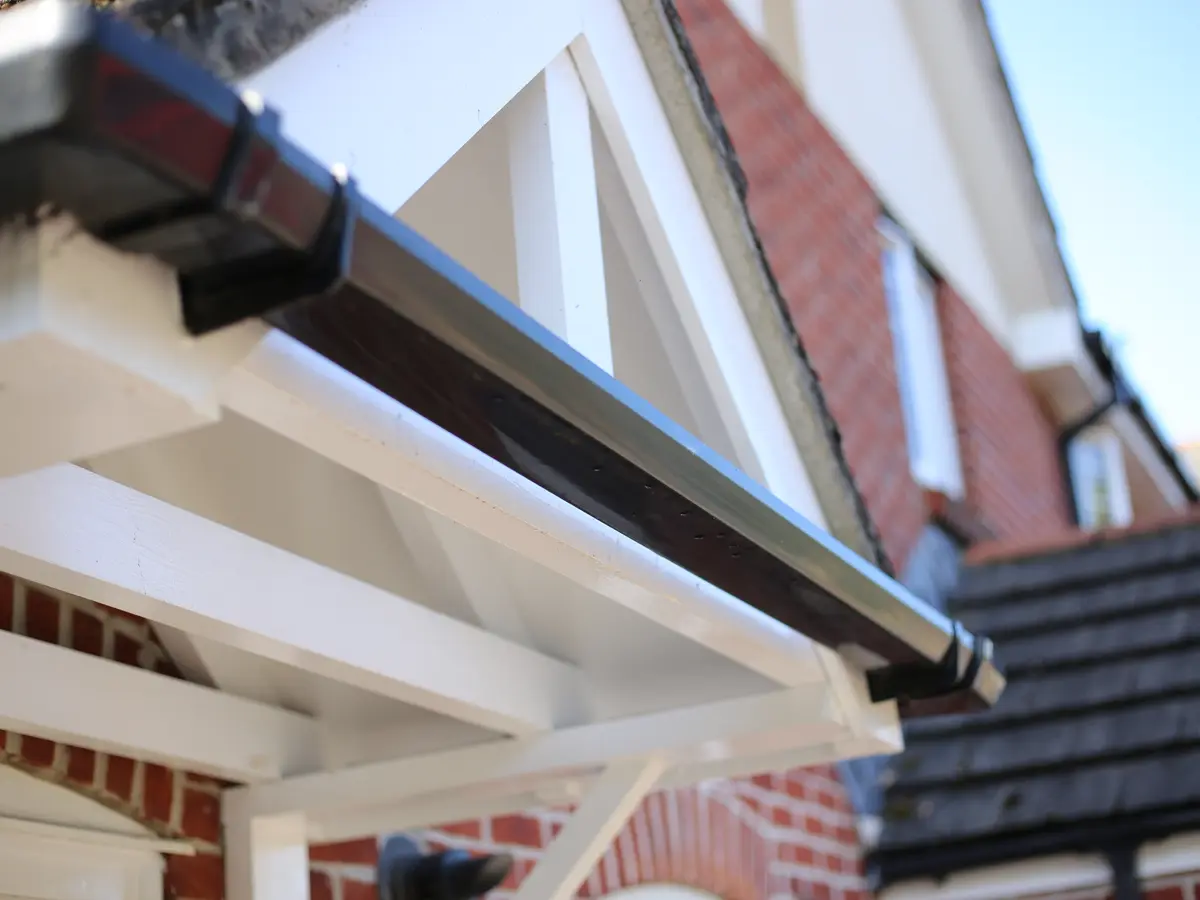 Black gutter running along a white porch roof