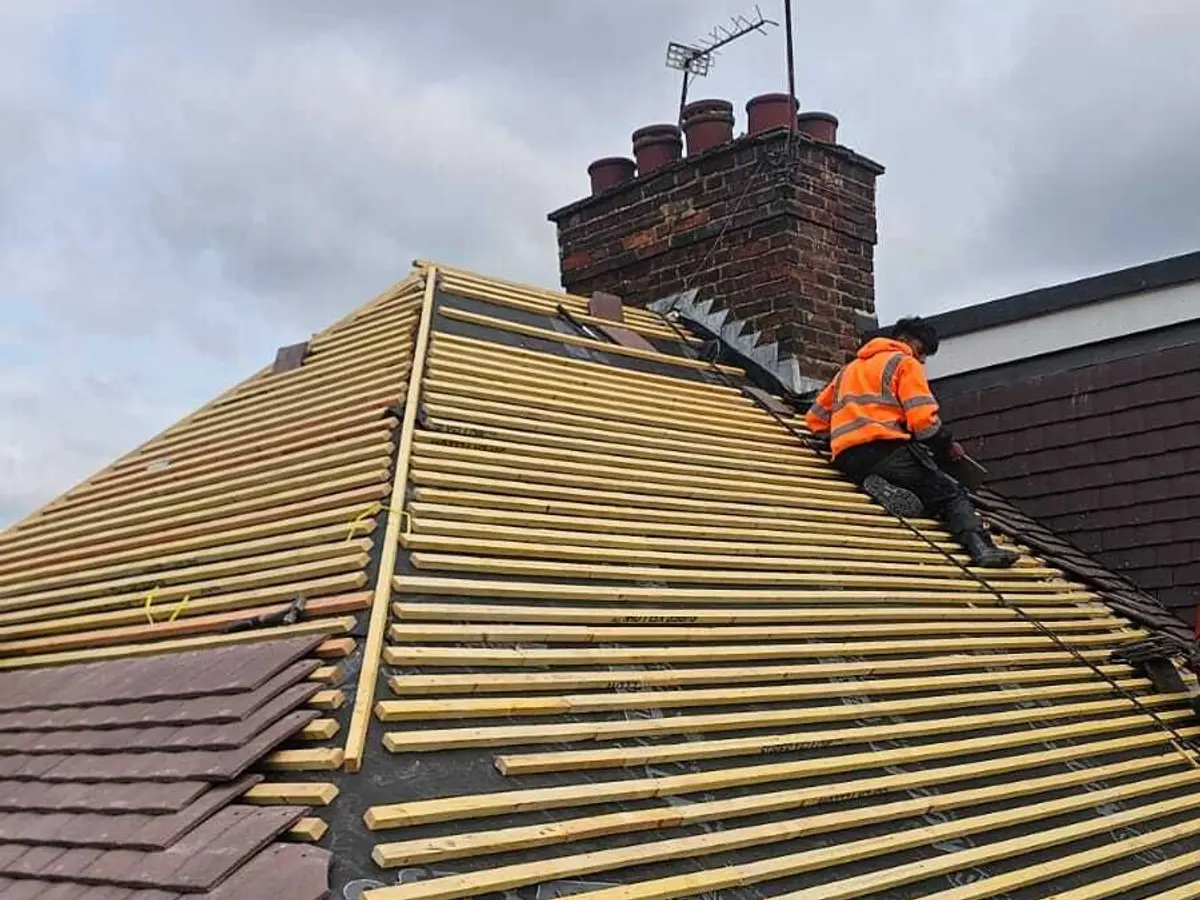 Roofer fixing new timber battens over breathable membrane