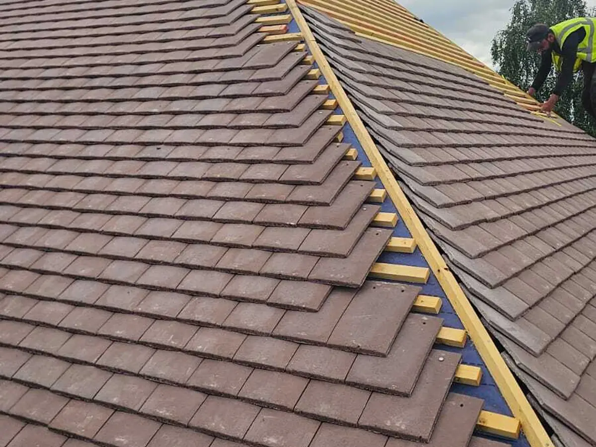 New plain tiles being laid over battens and membrane