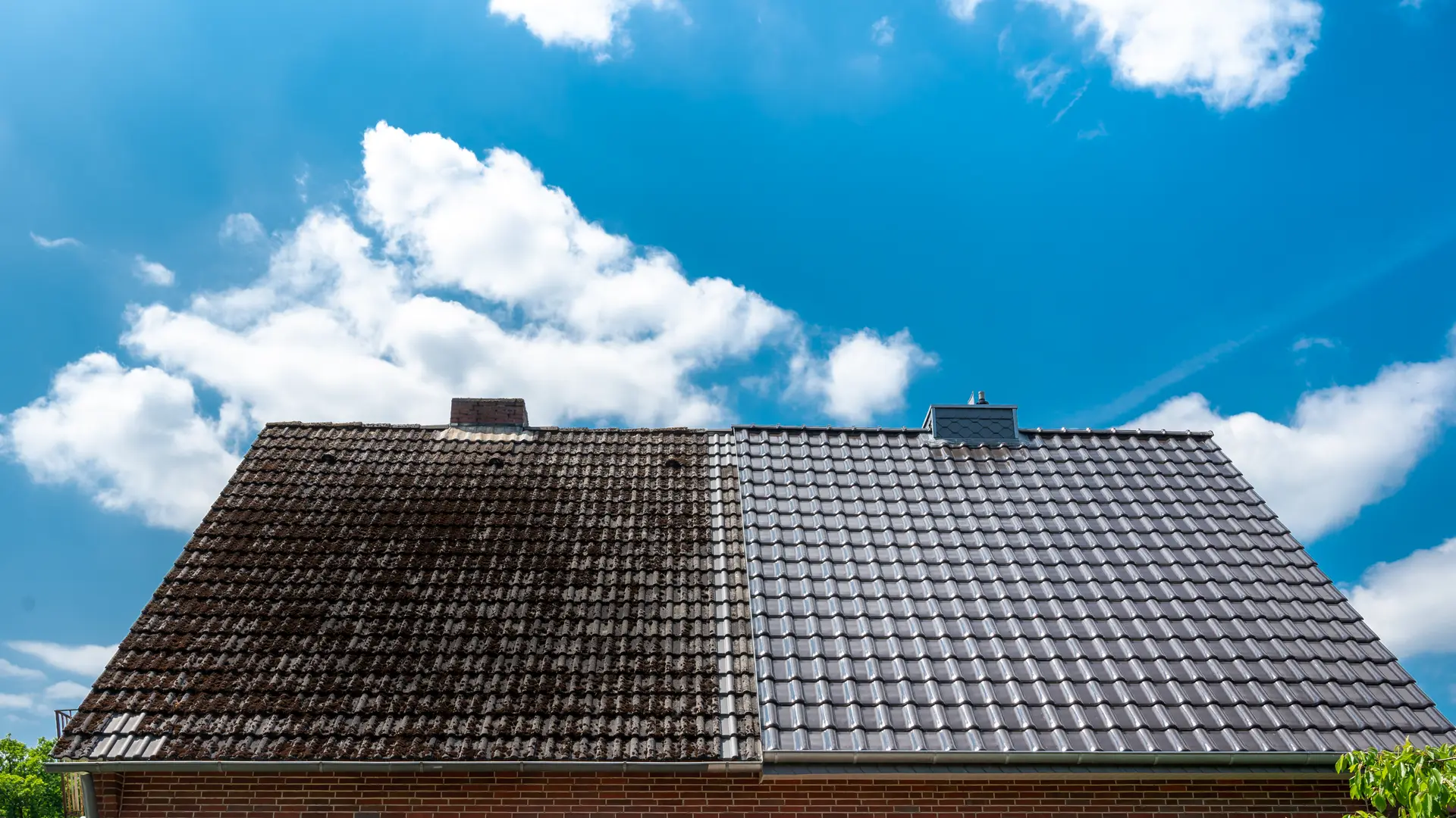 Tiled roof with moss covered and cleaned sections side by side